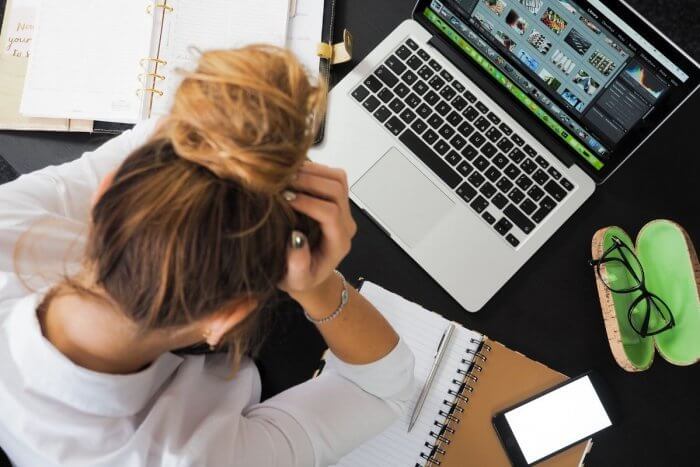 Lady with hair tied up in not looking despairingly on computer - worrying about my health