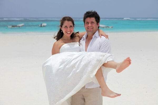 Married couple on a beach - can sex postpone your period?