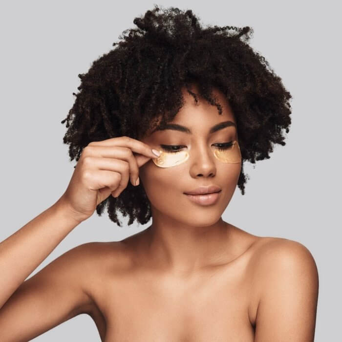 Topless photo of a lovely lady with smooth light brown skin applying face cream