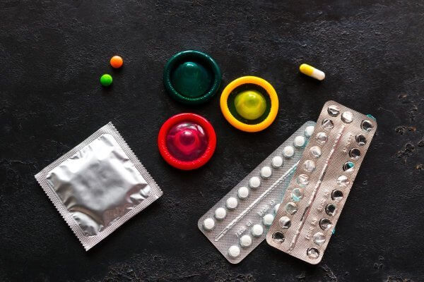 different birth control methods on a black background